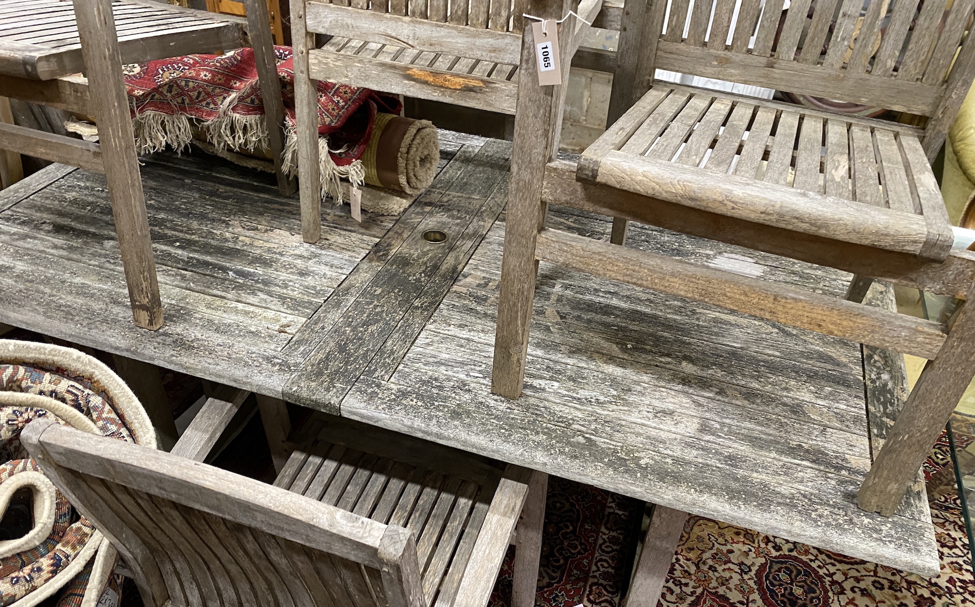A rectangular weathered teak extending garden table, minimum length 190cm, depth 109cm, height 74cm and eight elbow chairs